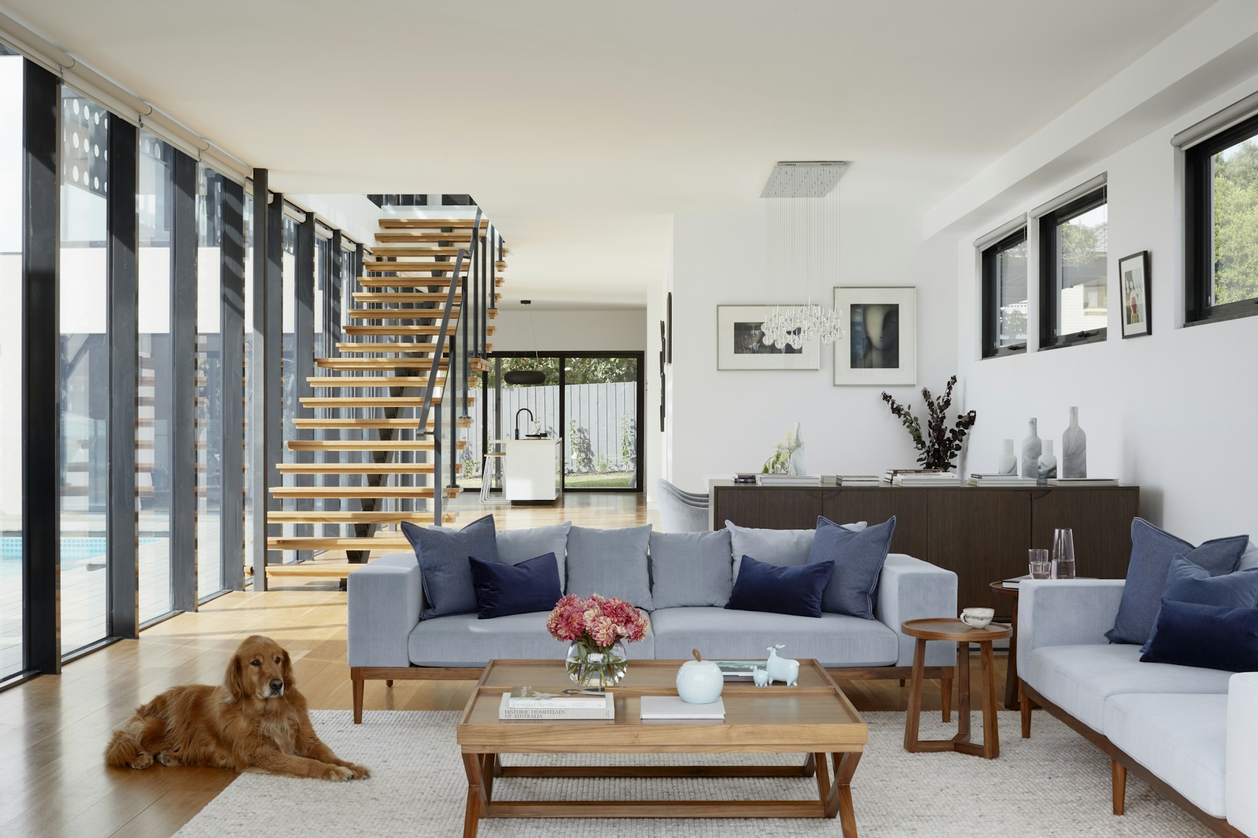 Spotless luxury living room with bright windows and natural greenery